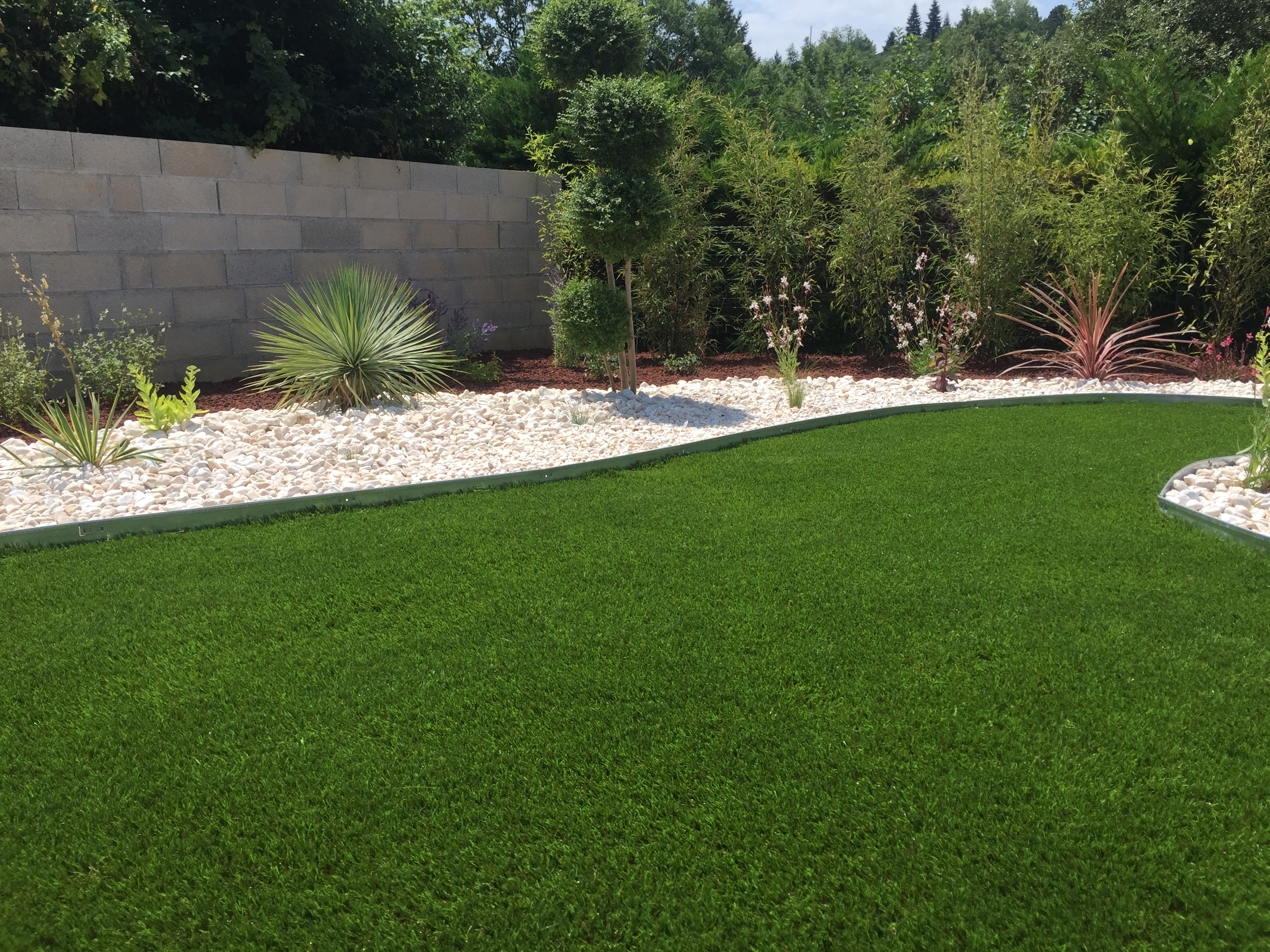 Aménagement d'un massif et tour de piscine : aménagement et pose du gazon synthétique terminé